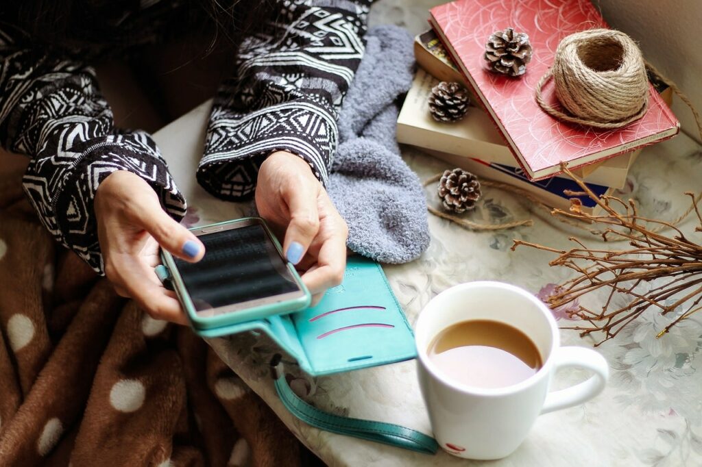 Una ragazza acquista i vari servizi social media marketing da uno smartphone e davanti al caffè